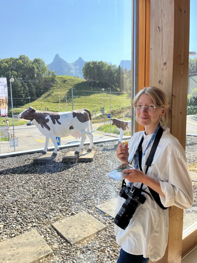 Bild på lantbruksjournalisten Kristina Hansén på kongress i Schweiz med kostaty i bakgrunden.